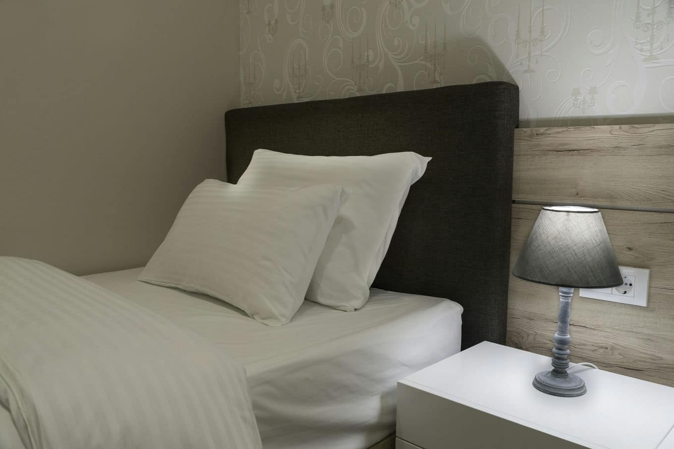 pojedyncze łóżko i lampka nocna na stoliku